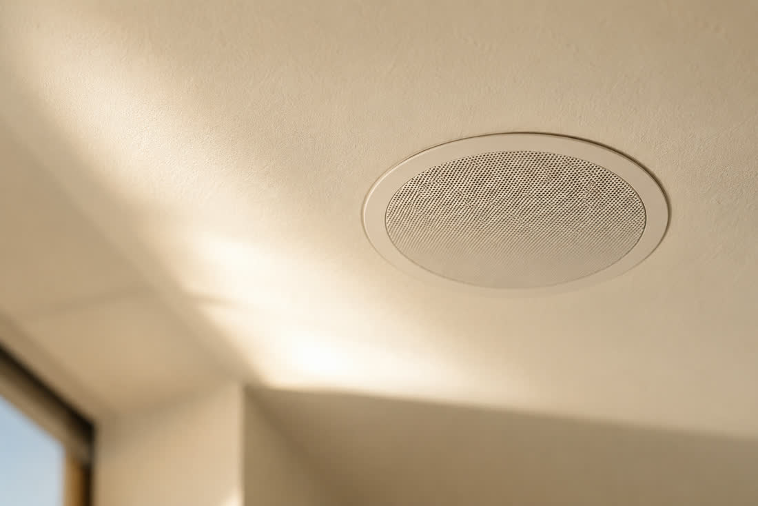 A flush in-ceiling speaker in a sunlit room