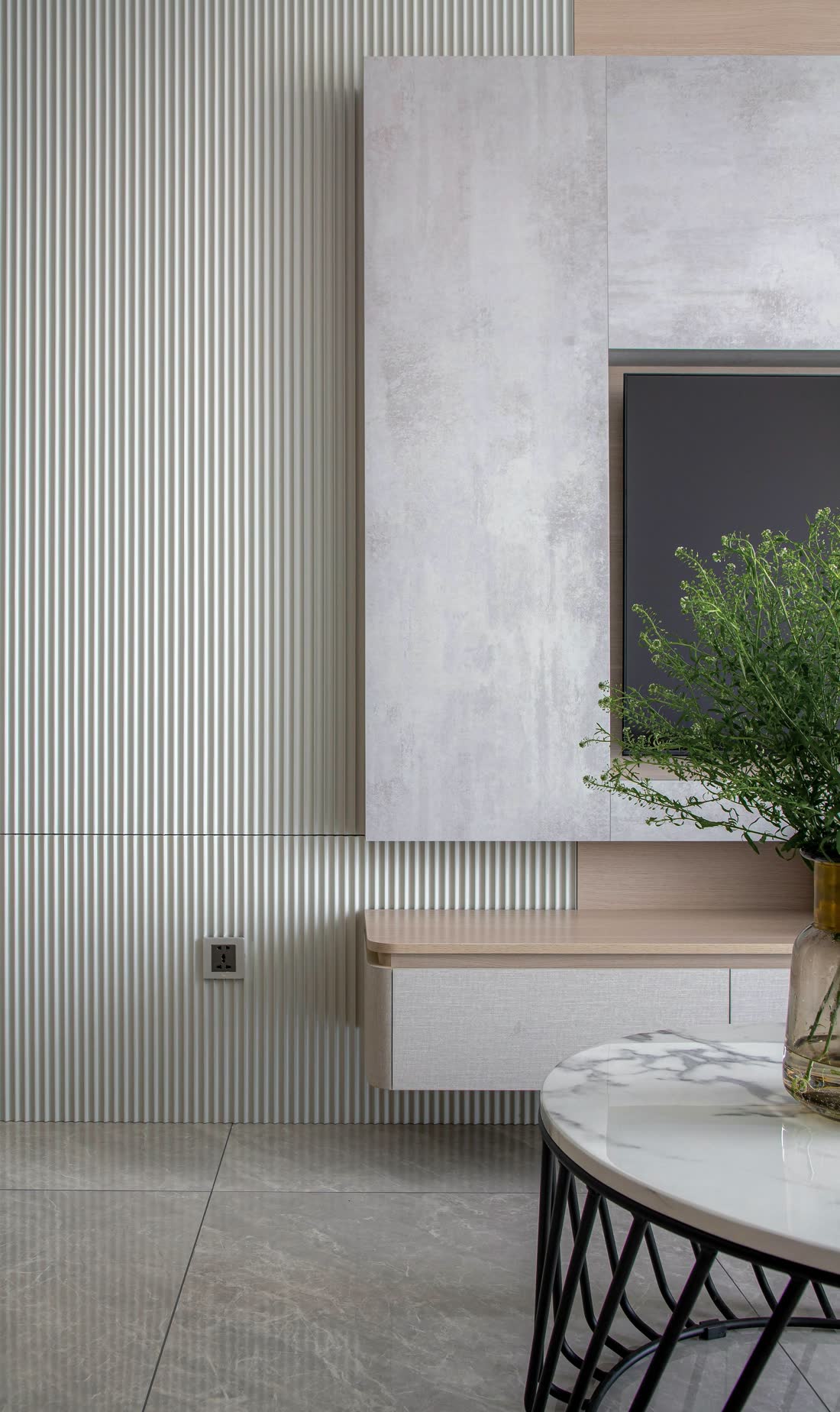 A media room with a concealed display set into a warm wood-slat wall